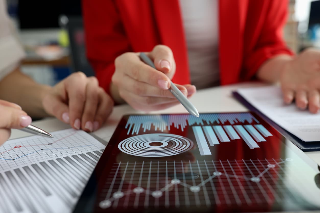 A sales team going over sales data displayed on a table device to increase sales