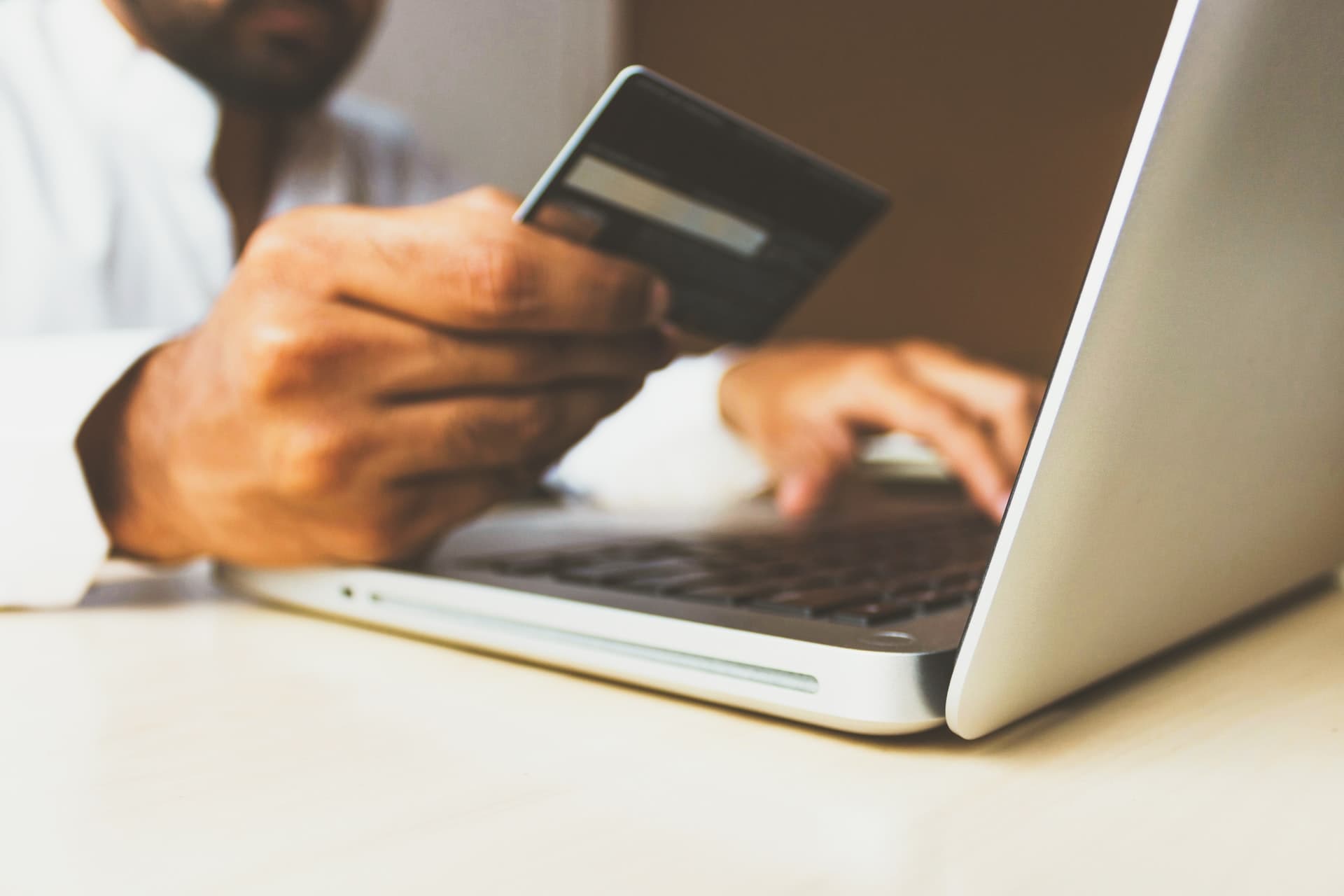 Man at a laptop with a credit card