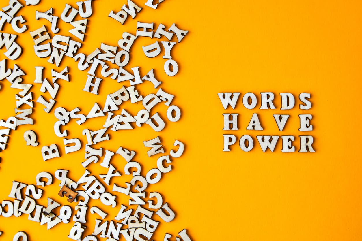 A jumble of letters on side and a sentence reading “Words have power” on the other