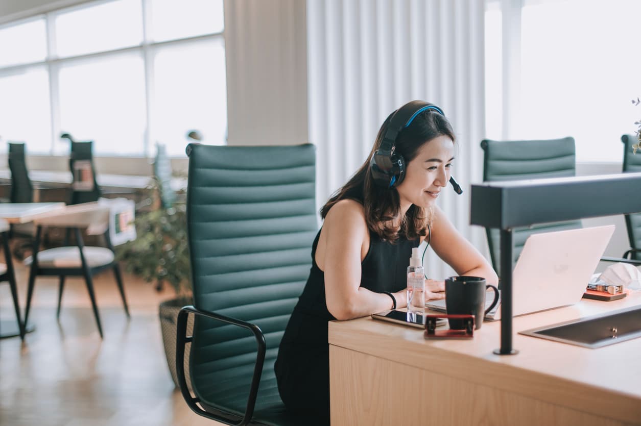 A young Asian woman participates in a Zoom call and shows her employees how to build a resilient sales team.