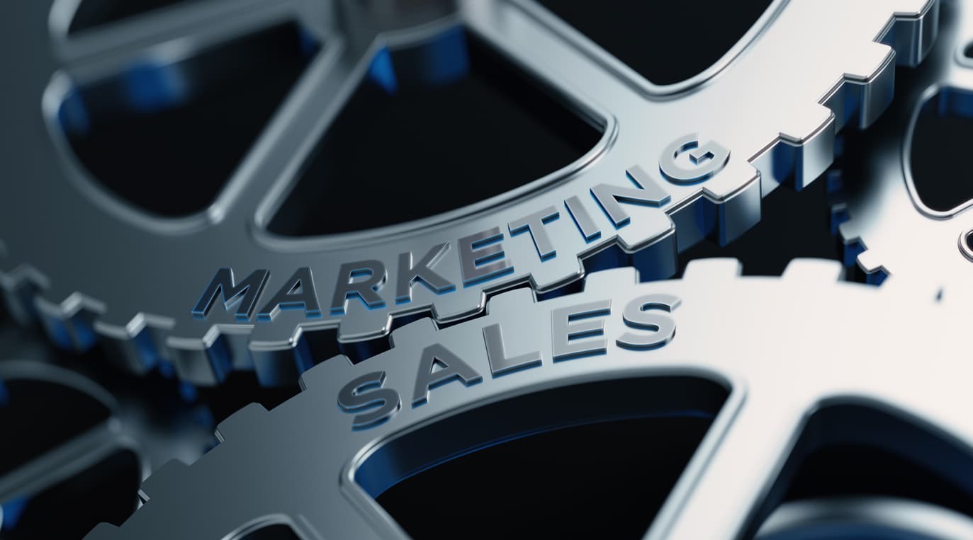 Gray silver metal cogs labeled sales and marketing to designate the need for sales and marketing alignment