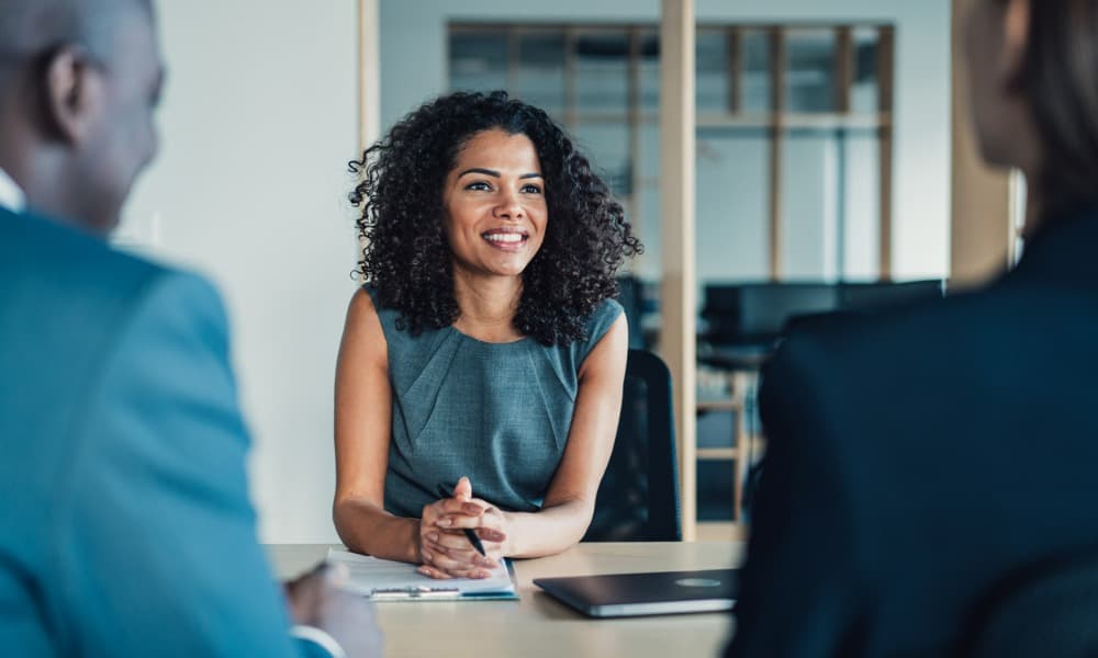 A woman discussing sales improv techniques with two colleagues