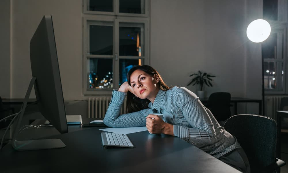 A woman experiencing a slump in sales staring blankly at a computer screen.